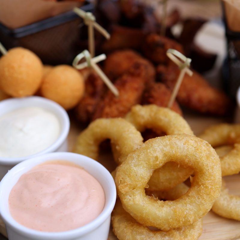 Onion rings, hush puppies, and fried sides with dipping sauces